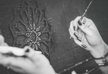 Jak Arabia Saudyjska inwestuje w kulturę i sztukę, by przyciągać turystów z całego świata Ręce malujące pędzlem monochromatyczne dzieło sztuki w Rijadzie